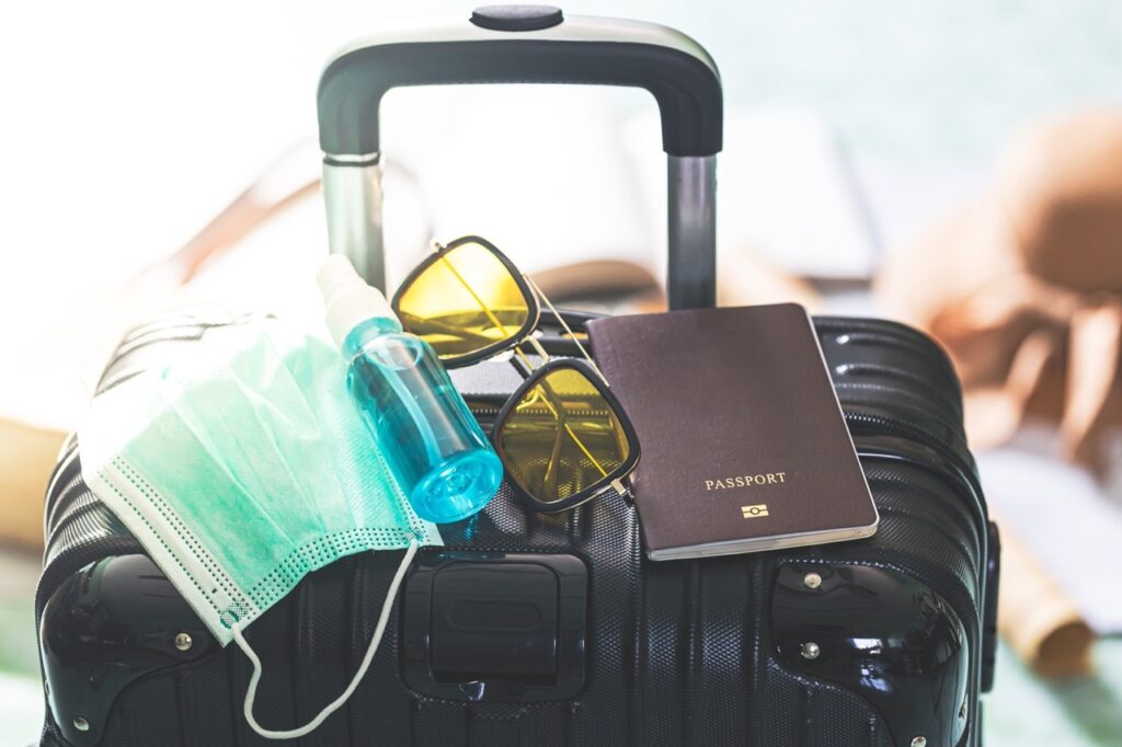 Travel luggage with mask, sanitizer, and passport for allergy-safe journey