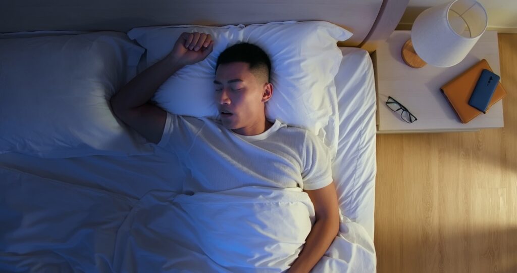 Man sleeping restlessly at night due to allergy symptoms disrupting sleep