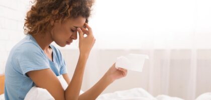 Woman with ongoing allergy symptoms holding tissue