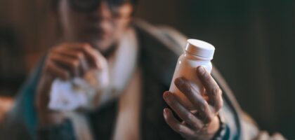Person holding over the counter allergy medication bottle